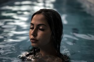 woman in swimming pool eyes closed